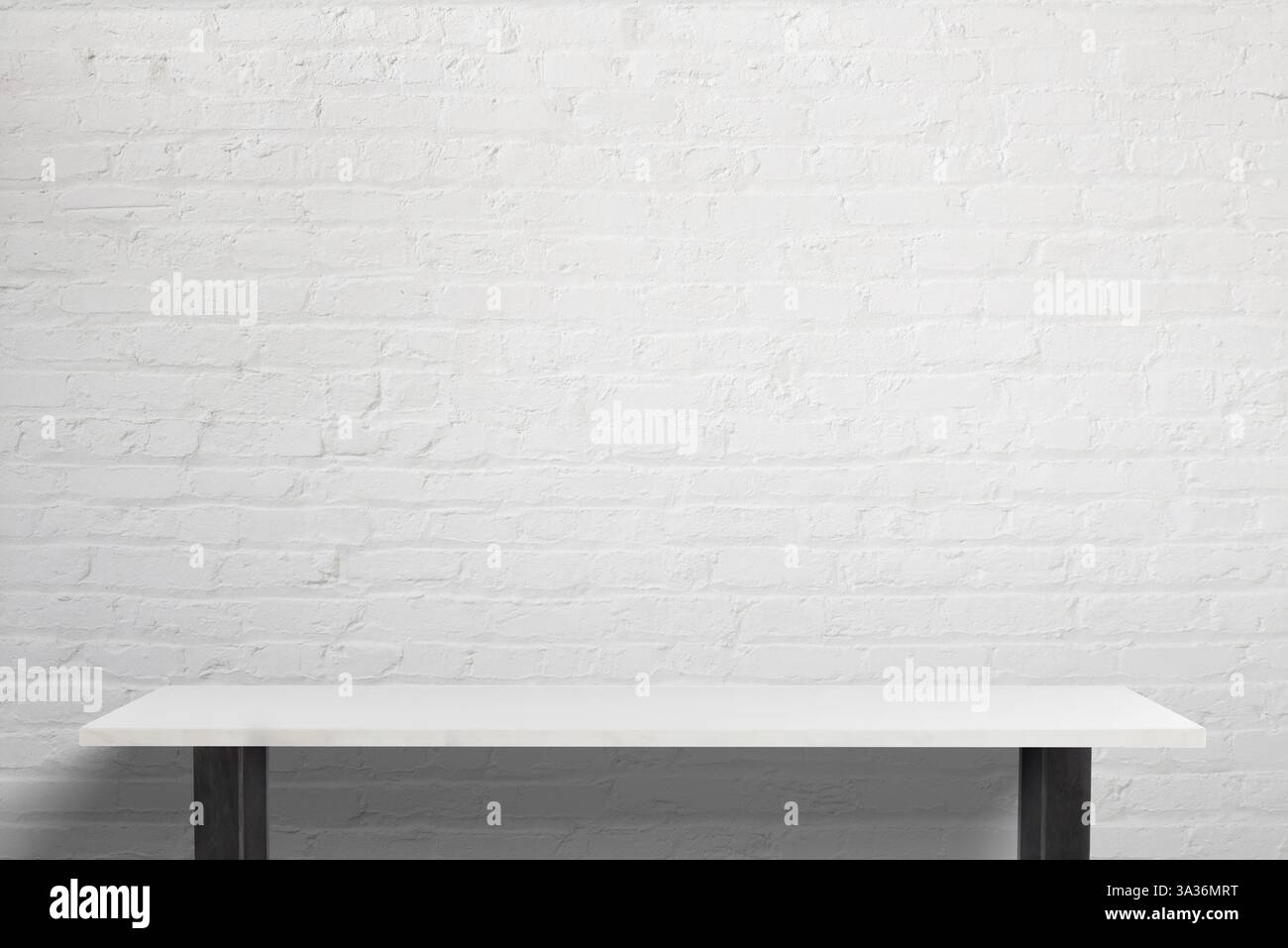 Espace de travail minimaliste avec une table blanche élégante avec des pieds noirs, un éclairage lumineux et un fond de briques blanches, parfait pour la marque de bureau et la cre Banque D'Images