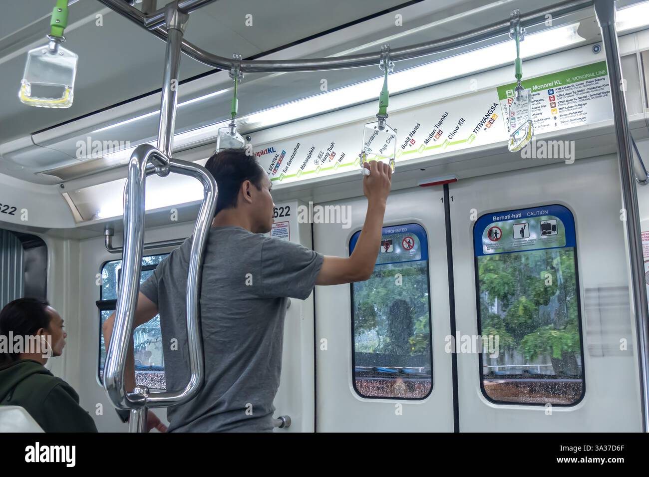 L'intérieur d'un train RapidKL Scomi SUTRA à Kuala Lumpur, en Malaisie, avec des navetteurs à bord Banque D'Images