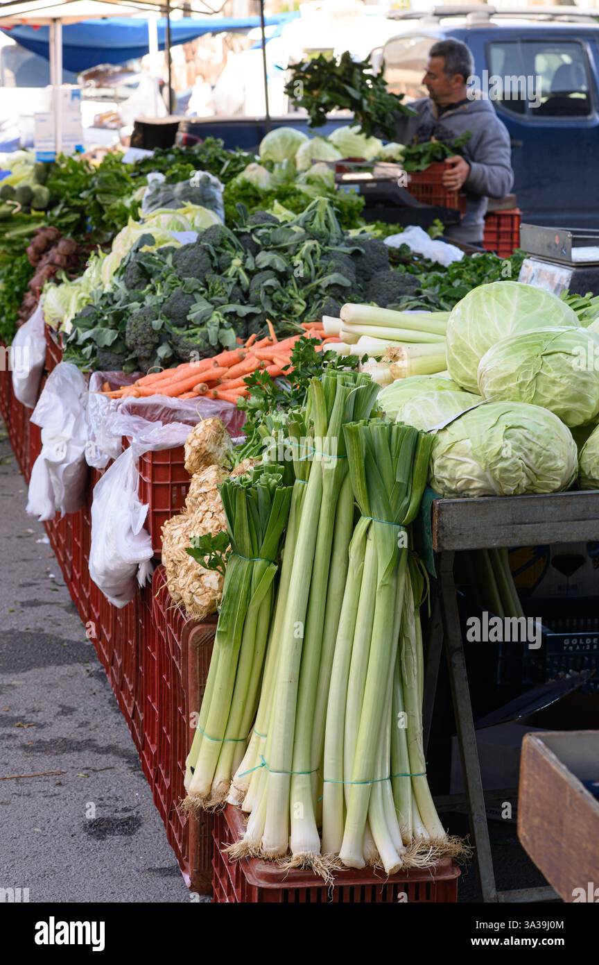 Légumes verts frais et croquants : laitue, épinards, chou frisé, poireaux, et les herbes – sont magnifiquement arrangées dans un marché bio de fermiers animé Banque D'Images