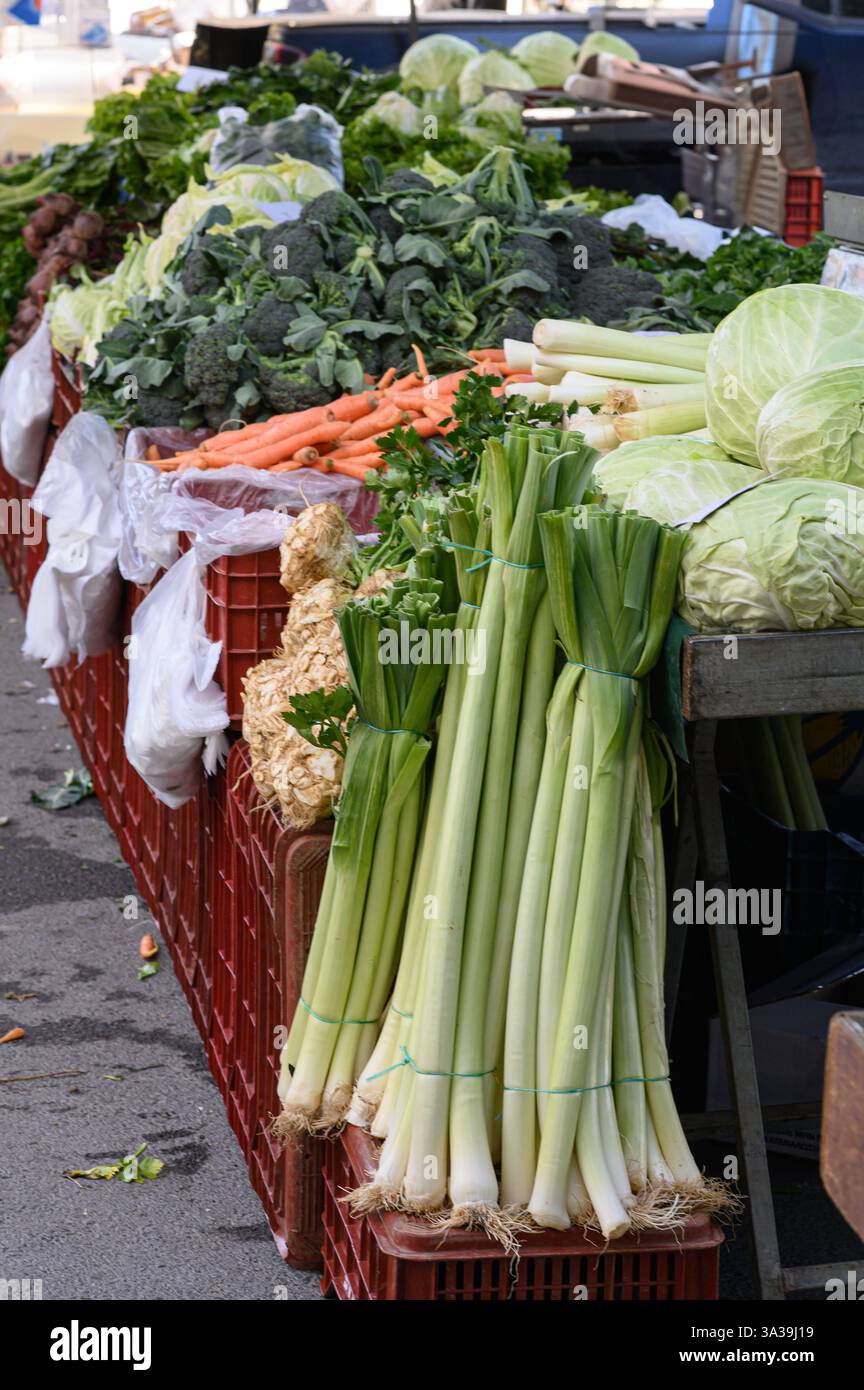 Légumes verts frais et croquants : laitue, épinards, chou frisé, poireaux, et les herbes – sont magnifiquement arrangées dans un marché bio de fermiers animé Banque D'Images