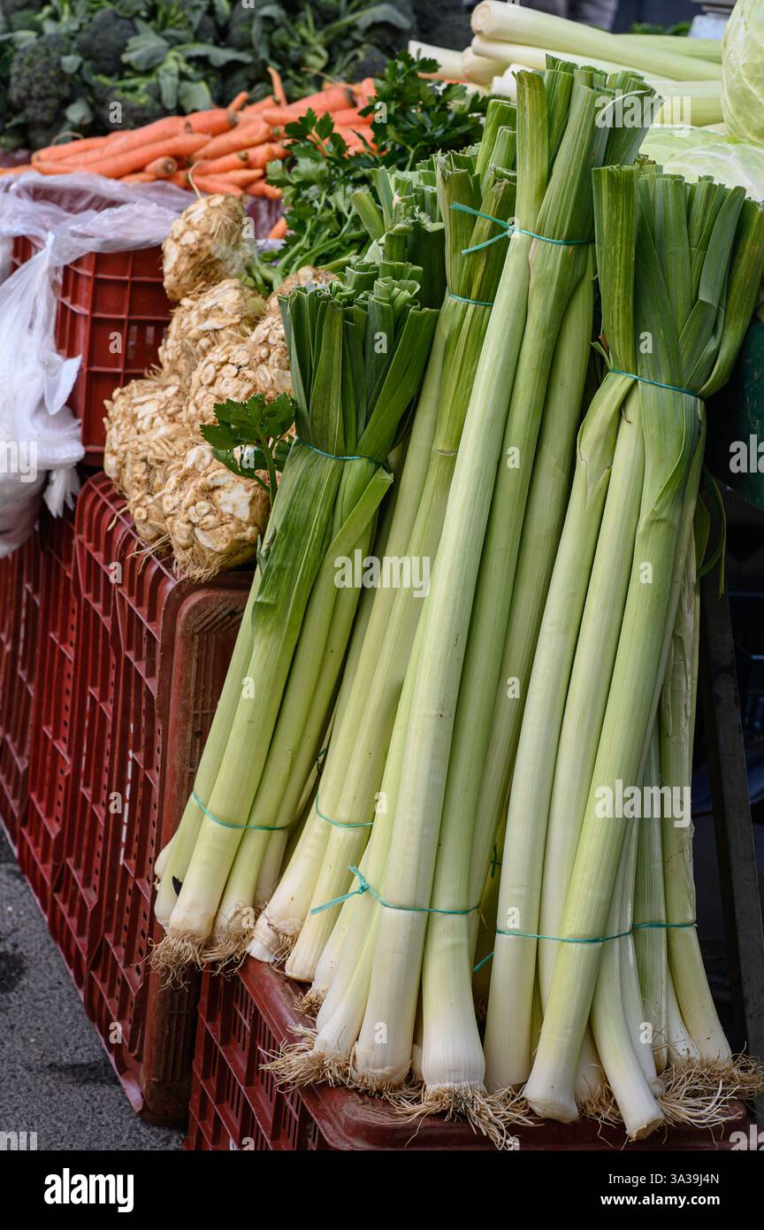 Légumes verts frais et croquants : laitue, épinards, chou frisé, poireaux, et les herbes – sont magnifiquement arrangées dans un marché bio de fermiers animé Banque D'Images