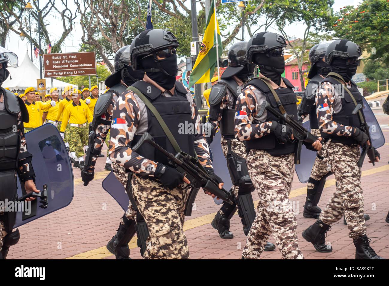 Les soldats camouflent des uniformes et des casques avec des couvre-visage noirs, portant des boucliers et des fusils, marchant en formation Journée nationale Melaka Malaisie Banque D'Images