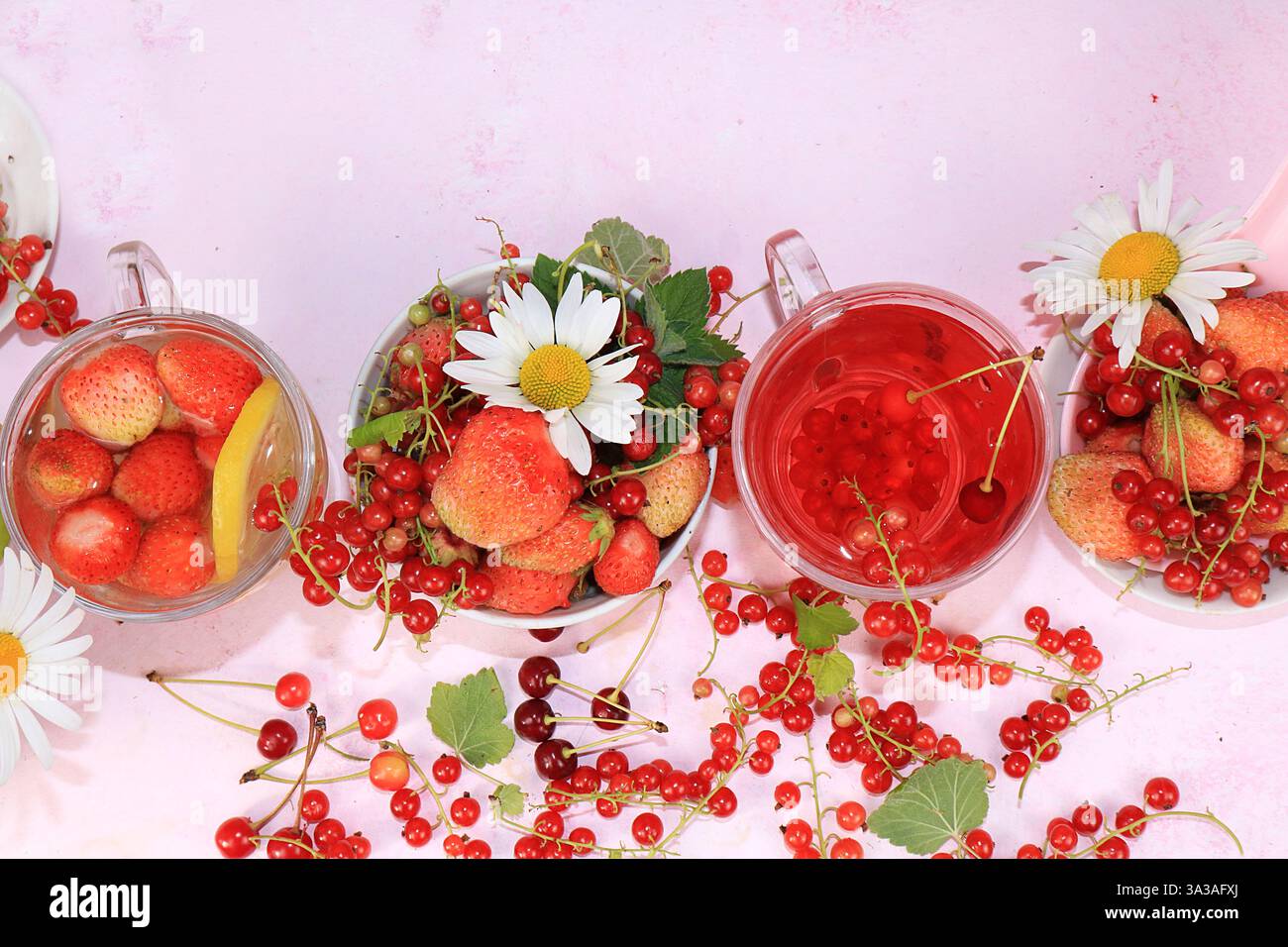 Boissons estivales, jus de fraise et de groseille avec baies. Délicieuse limonade molle de groseilles et de fraises sur un fond rose, vue de dessus, copie Banque D'Images