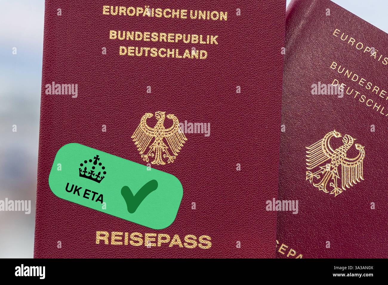 Bavière, Allemagne - 14 mars 2025 : PHOTOMONTAGE, un passeport allemand avec un autocollant vert UK ETA et une coche montrant la demande réussie Genemigt pour l'autorisation de voyage numérique requise pour entrer au Royaume-Uni. *** FOTOMONTAGE, ein deutscher Reisepass mit einem grünen UK ETA Aufkleber und Häkchen zeigt die erfolgreiche Beantragung Genemigt der digitalen Reisegenehmigung, die für die Einreise nach Großbritannien erforderlich ist. Banque D'Images