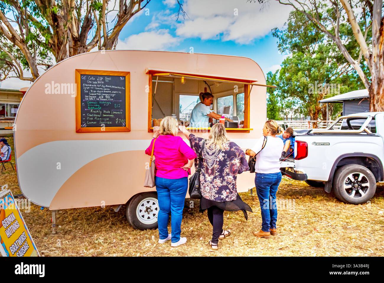Les clients attendent un verre dans un café caravane vintage au Moonbi Showground, Nouvelle-Galles du Sud, Australie. Banque D'Images