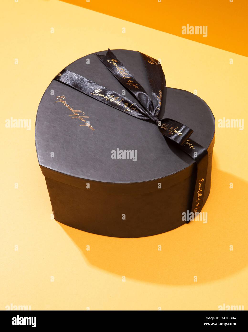 Coffret cadeau romantique en forme de coeur noir avec ruban et texte « magnifique ». Idéal pour la Saint-Valentin et les promotions sur le thème de l'amour Banque D'Images