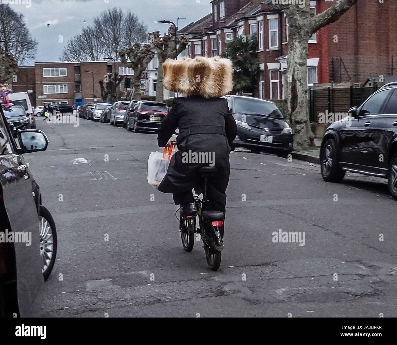 Un Juif hassidique portant un cycle spodik extra large à Stamford Hill à Londres pendant Pourim. Banque D'Images