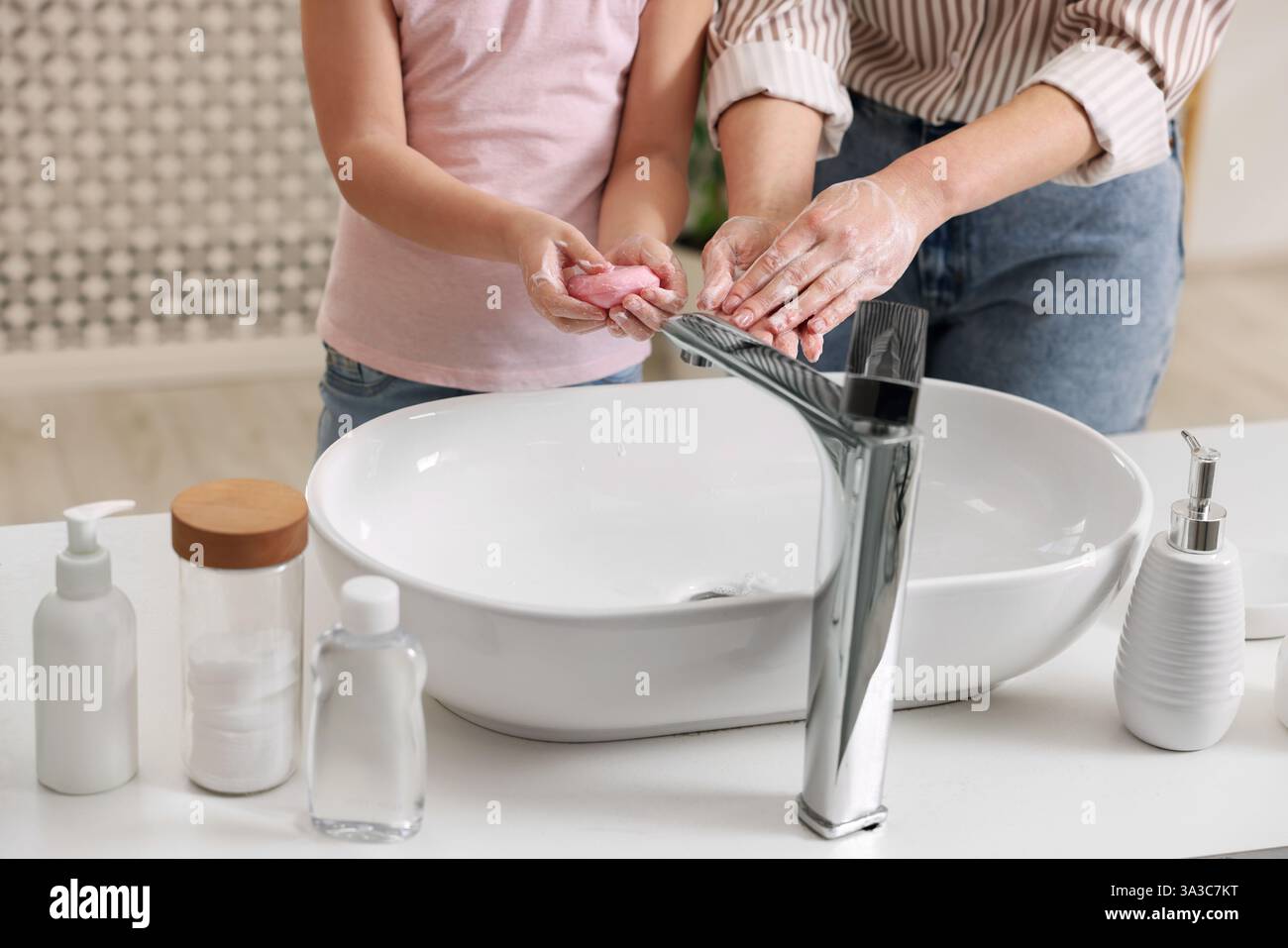 Mère et fille se lavant les mains à l'intérieur, gros plan Banque D'Images
