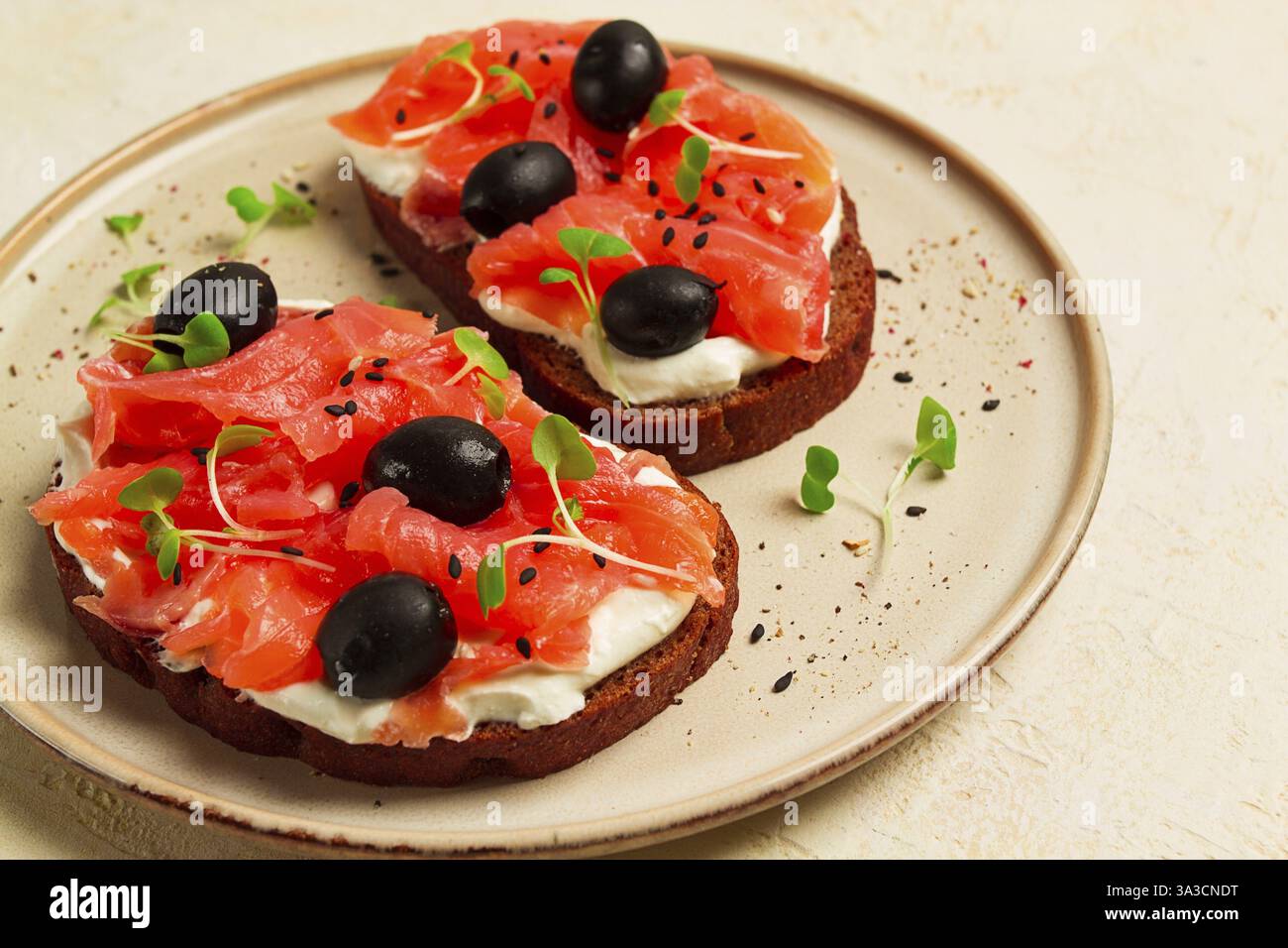Sandwichs avec poisson rouge, fromage à la crème, olives et microgreens, petit déjeuner Banque D'Images