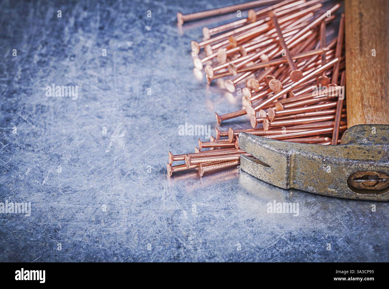 Clous de construction en cuivre de marteau à griffes vintage sur fond métallique Banque D'Images