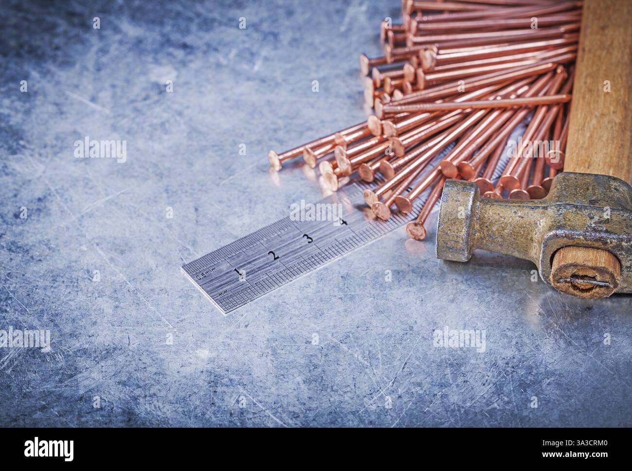 Vintage griffe marteau de construction en cuivre clous règle en métal sur fond métallique Banque D'Images