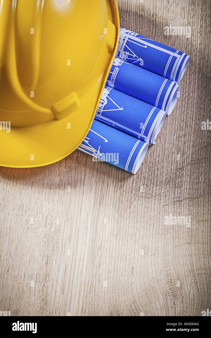 Planche en bois avec bleu enroulé plans de construction construire casque Banque D'Images