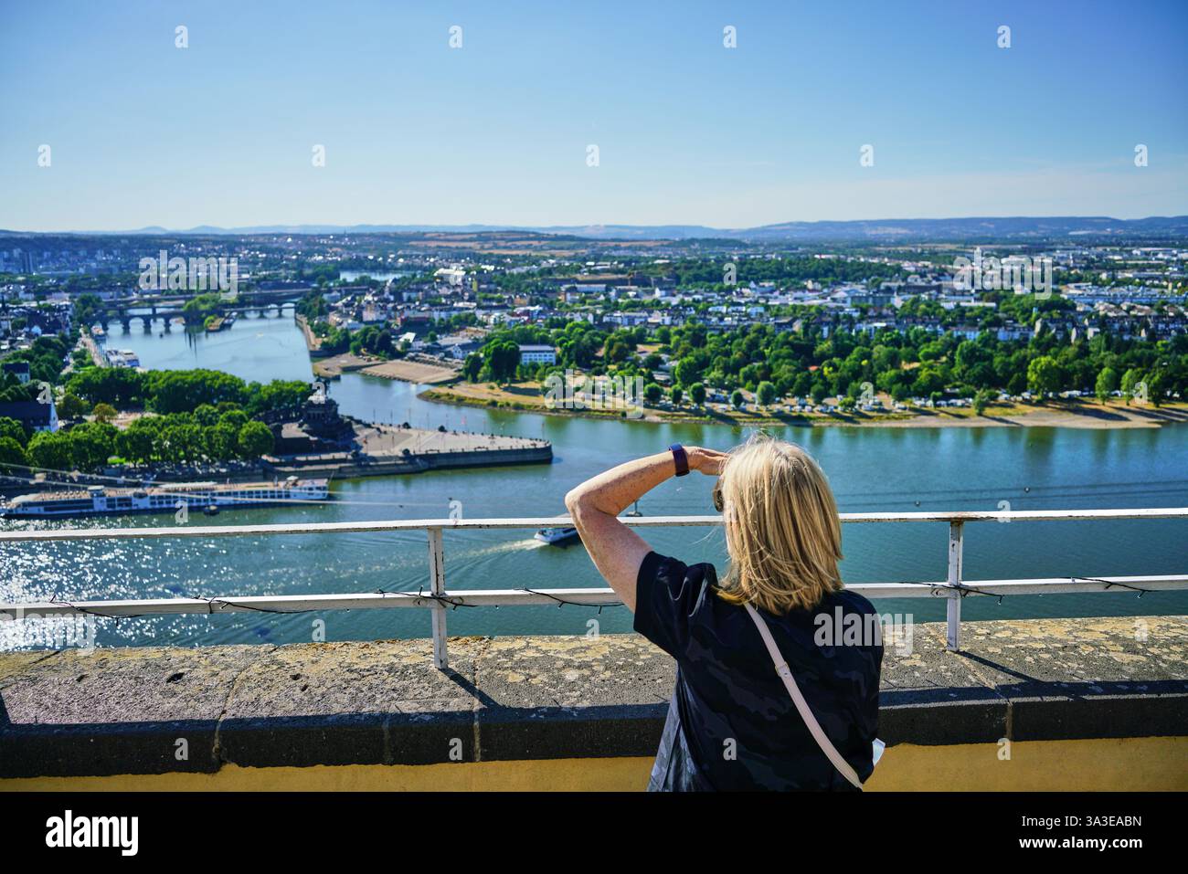 La femelle blonde jouit de la vue sur le Rhin et la Moselle au coin de l'Allemagne à Coblence, depuis la forteresse d'Ehrenbreitstein. Banque D'Images