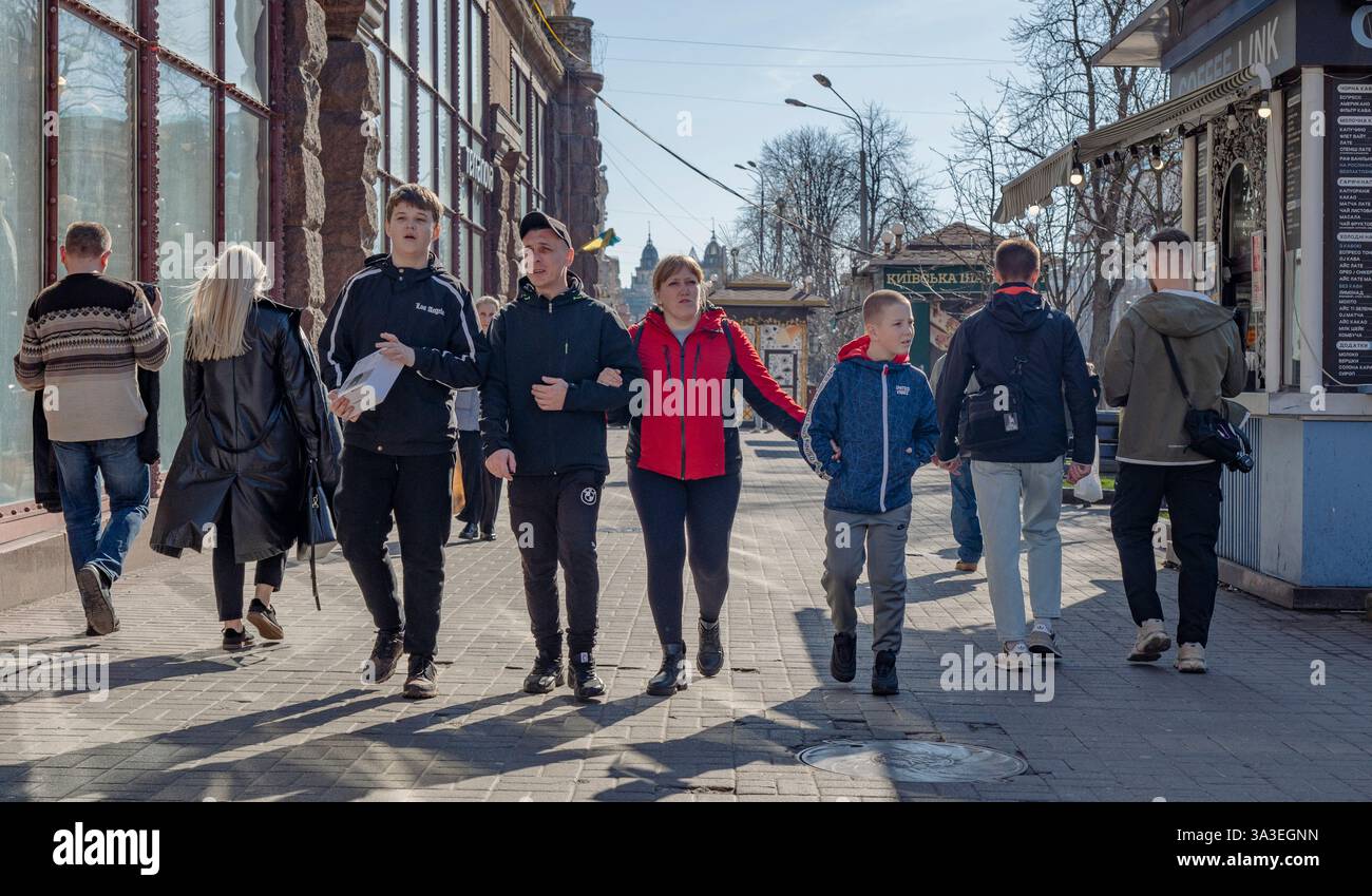 Kiev, Ukraine - 14 mars 2025. Des groupes d'amis se promènent le long de la rue animée, partageant des rires et créant des souvenirs sous le soleil. Banque D'Images