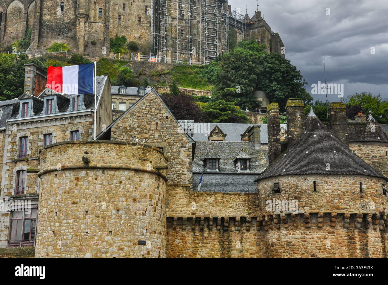 Vue sur le Mont Saint Michel avec drapeau français agitant fièrement, Normandie Banque D'Images