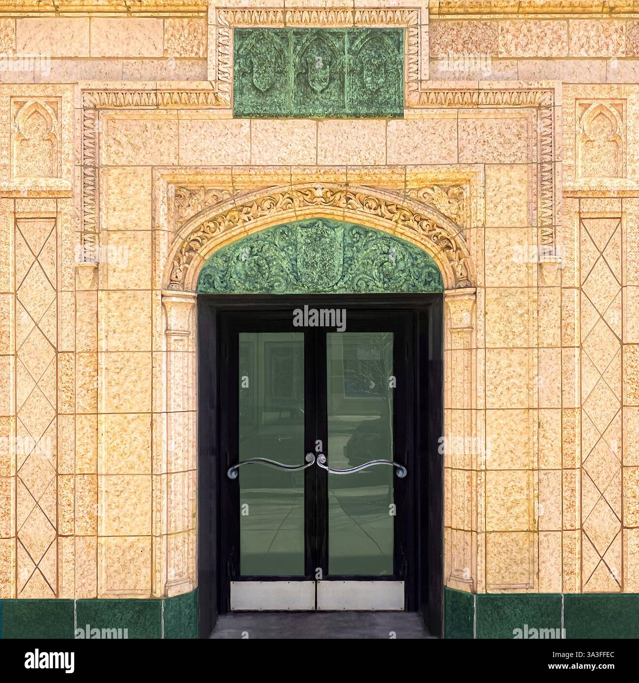 Une entrée ornée à double porte encadrée par des détails architecturaux verts complexes sur un bâtiment historique en terre cuite à Chicago. - Image de stock capturée avec un smartphone