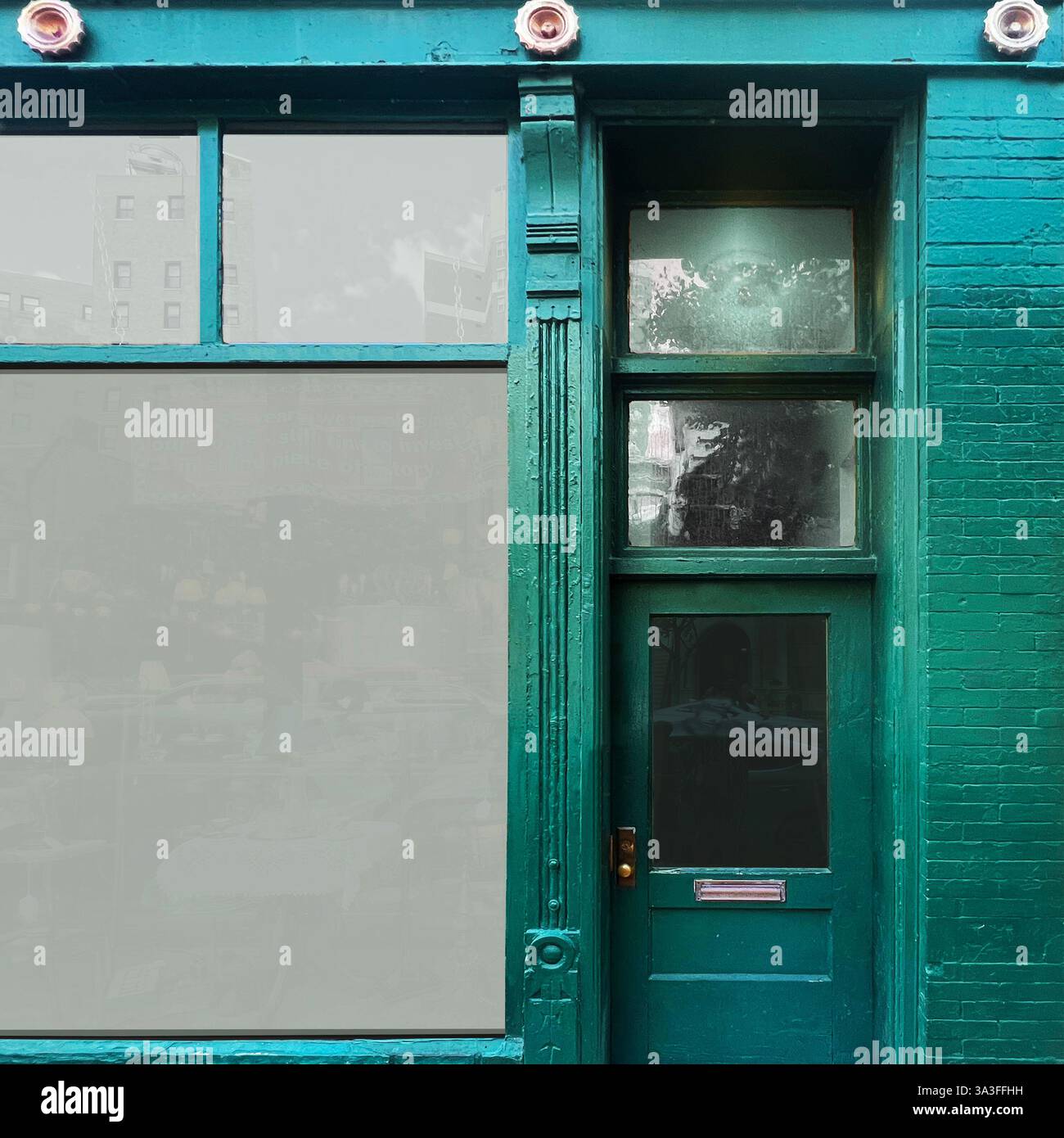 Une vitrine verte vintage avec de grandes fenêtres en verre reflète les bâtiments historiques environnants et le ciel dans un quartier de Chicago. Banque D'Images