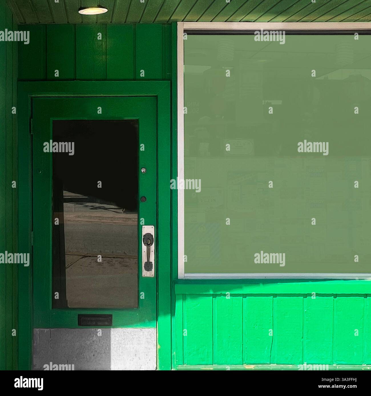 Une vitrine verte vibrante avec une porte en verre réfléchissante et une grande fenêtre, capturant le charme d'une entreprise de quartier classique à Chicago - Image de stock capturée avec un smartphone