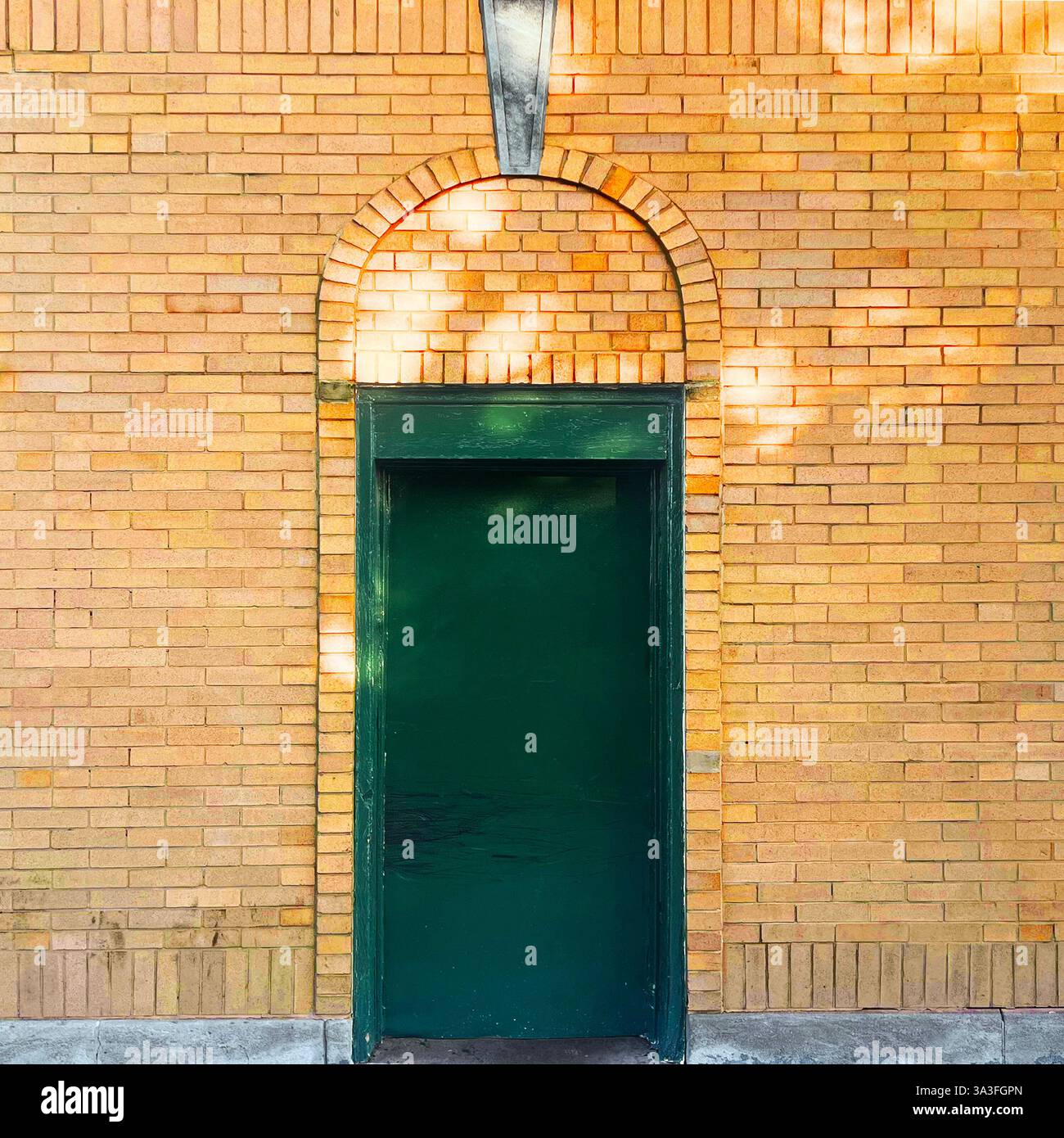 Une porte verte placée dans une arche courbée en briques jaunes dans une rue tranquille de Chicago. - Image de stock capturée avec un smartphone