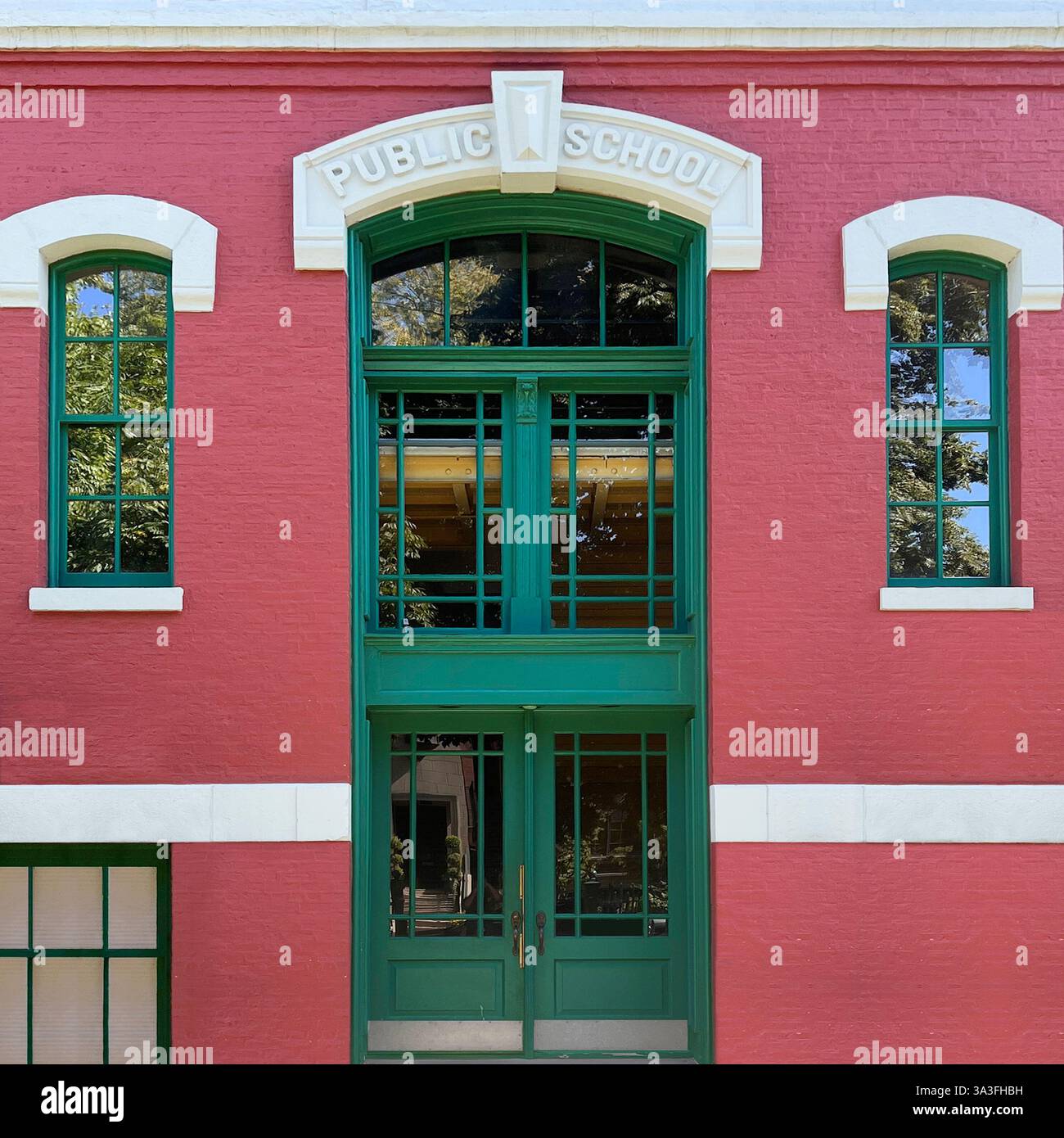 Une entrée d'école publique historique magnifiquement restaurée à Chicago, avec une porte verte avec des panneaux de verre complexes sertis contre la façade en briques rouges Banque D'Images