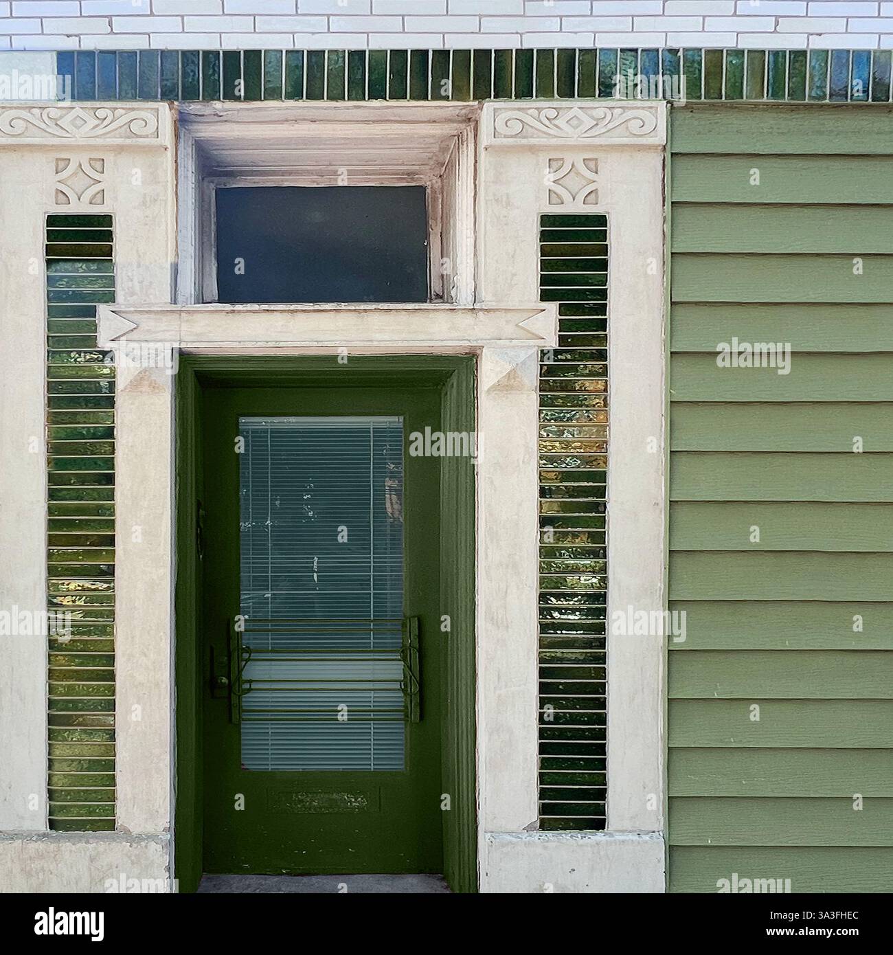 Une porte verte avec des briques vitrées décoratives et des détails architecturaux complexes sur une façade de bâtiment vintage de Chicago. Banque D'Images