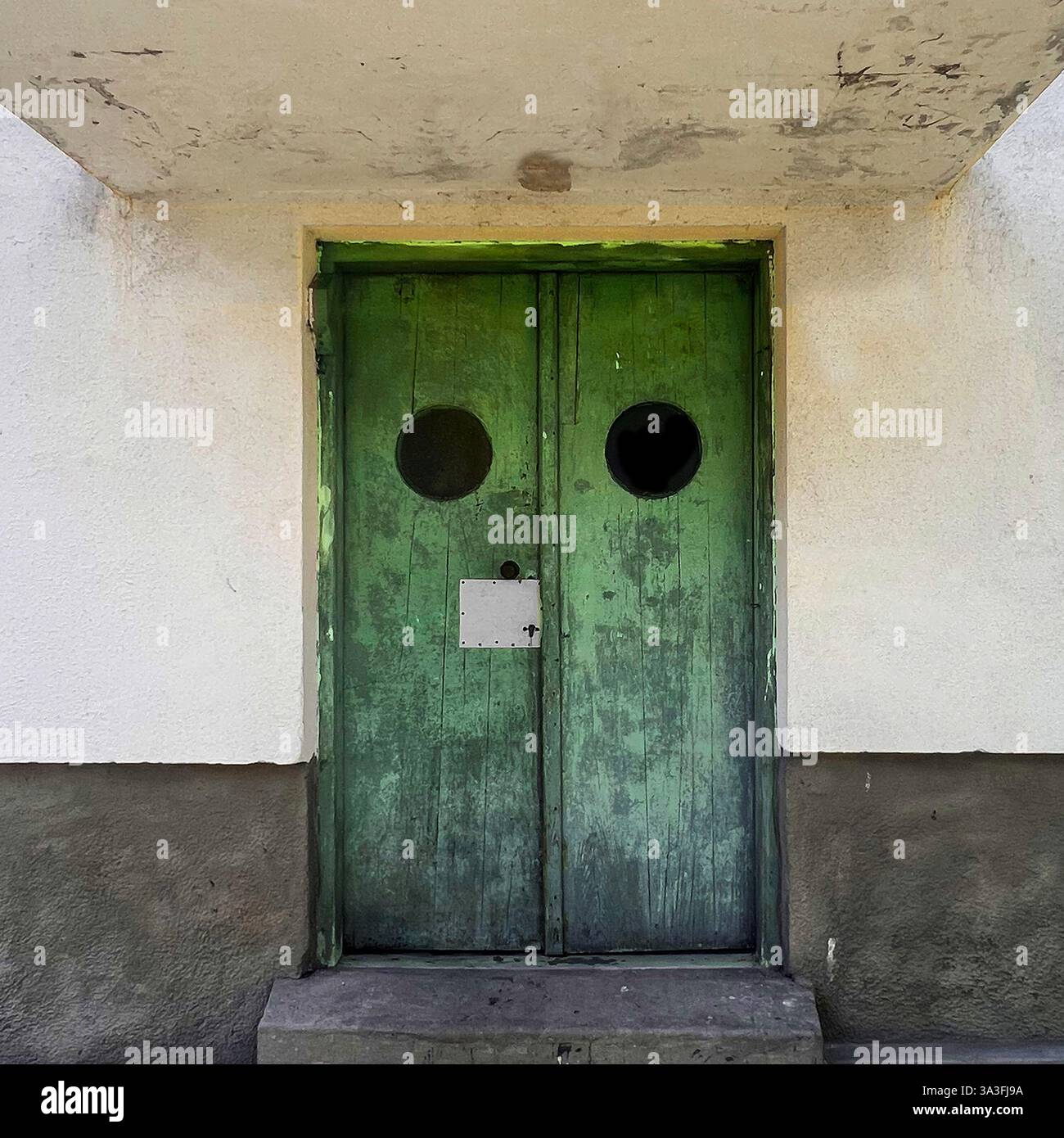 Une porte en bois vert vieilli avec des hublots ronds, mettant en valeur les influences Streamline moderne à Varsovie, en Pologne Banque D'Images