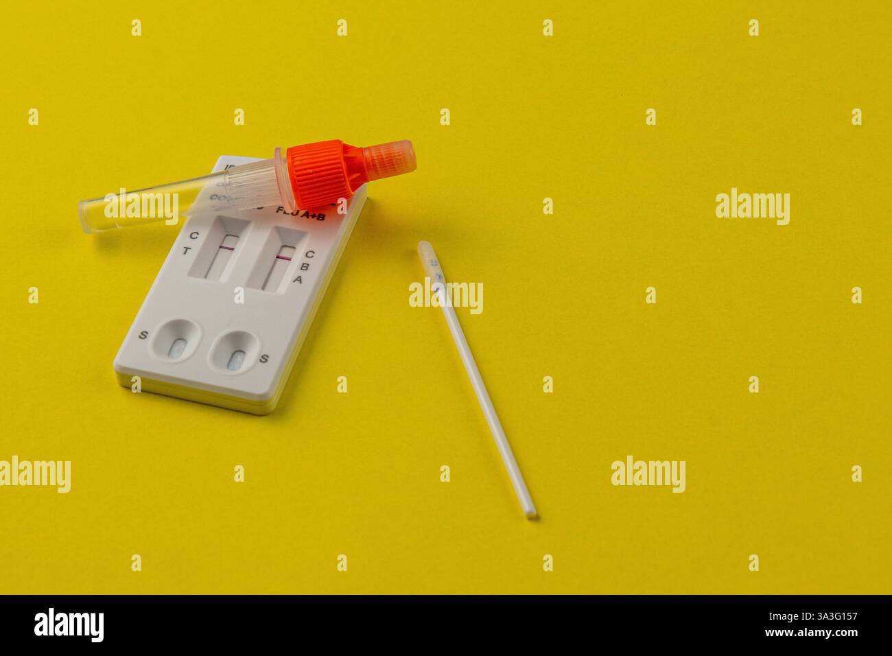 Un kit de test rapide repose sur une surface jaune vif, avec un petit flacon et un écouvillon. Il est conçu pour des tests de santé rapides et efficaces, appropriés Banque D'Images