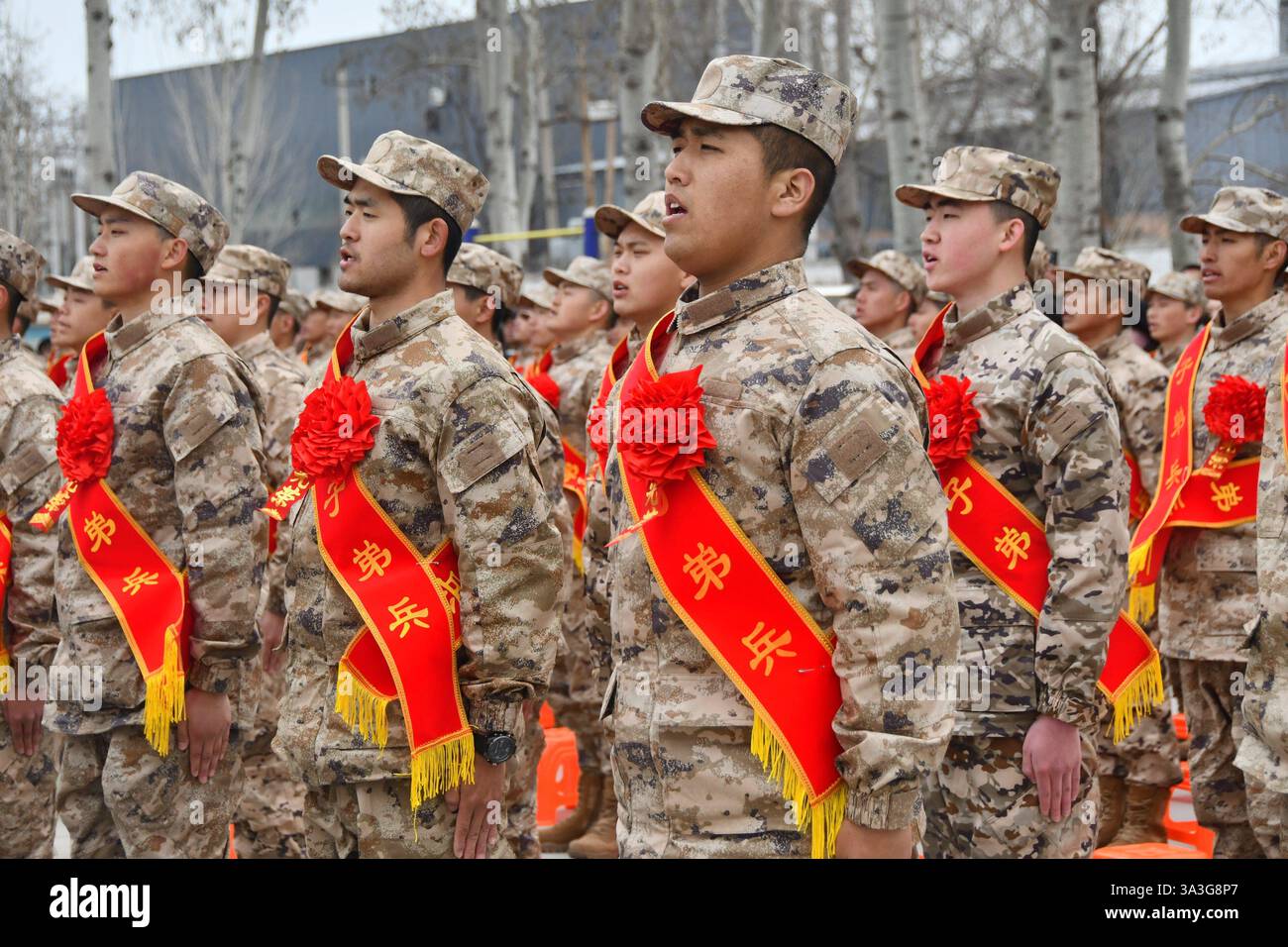 De nouvelles recrues chantent l'hymne national à la base d'entraînement de la milice dans le district de Yongnian à Handan, dans la province du Hebei, au nord de la Chine, le 15 mars 2025. Banque D'Images