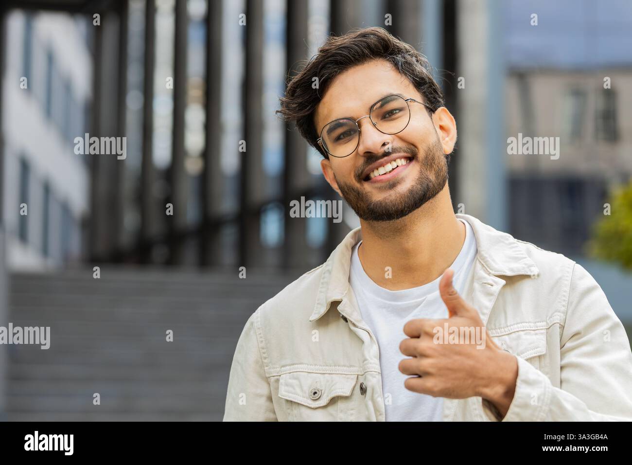 J'aime. Heureux homme indien lève les pouces vers le haut est d'accord avec quelque chose donne une réponse positive recommande la publicité aime la rétroaction de bonne idée, célébrant la victoire de succès. Arabian Guy debout dans la rue de la ville Banque D'Images