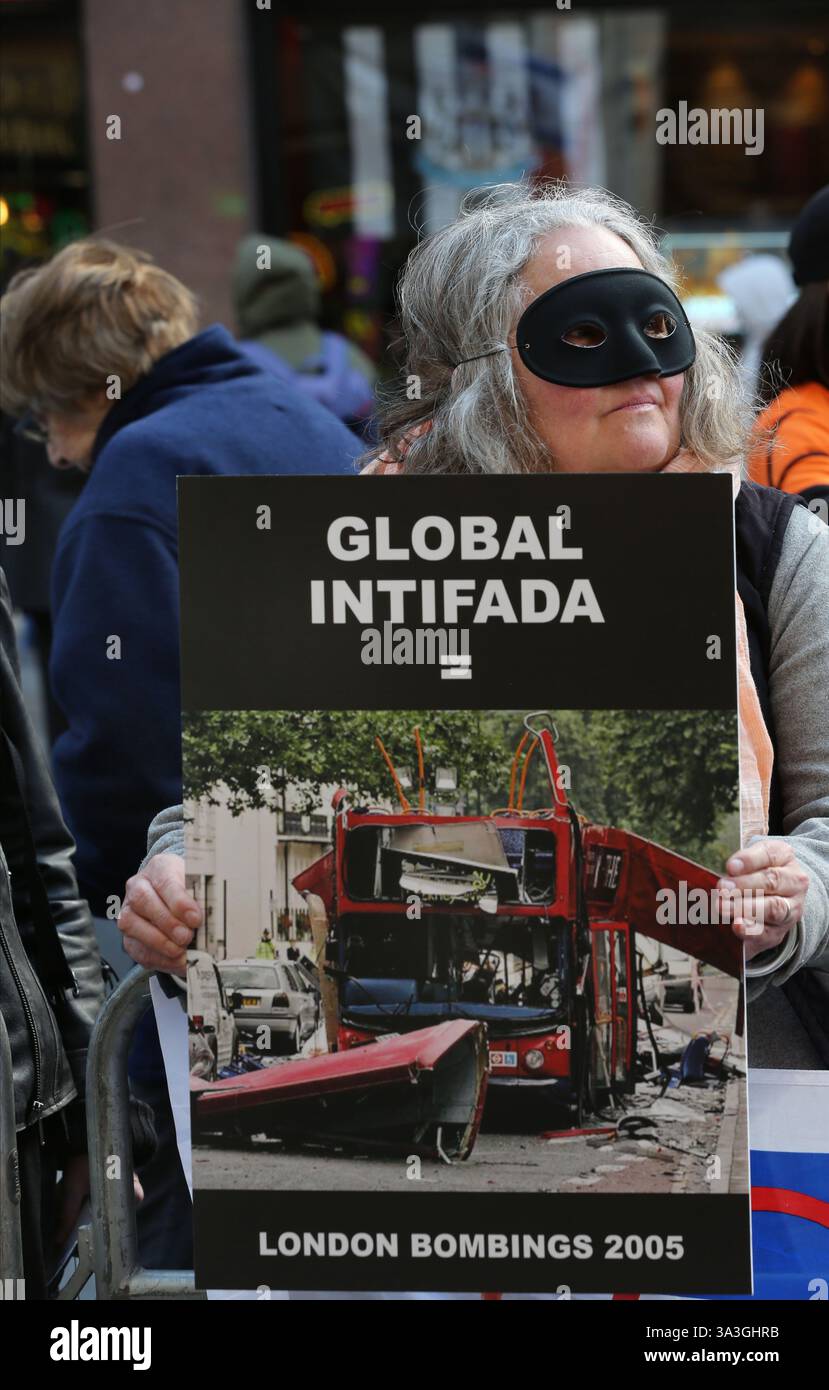 Un manifestant tient une pancarte indiquant « Global Intifada » et montrant une photo de l'attentat de Londres en 2005 pendant la contre-manifestation. Les manifestants pro-israéliens se rassemblent dans Coventry Street à Londres comme contre-manifestation à un rassemblement pro-palestinien. Les manifestants exigent le retour immédiat de tous les otages détenus par le Hamas. Ils portent des masques Batman et tiennent des pancartes et des ballons orange en hommage à Ariel Bibas, un amoureux de 4 ans du personnage de dessin animé qui a été tué avec d'autres membres de sa famille après une attaque aérienne israélienne alors qu'ils étaient retenus en otage à Gaza. (Photo de Martin Pope/SOP Banque D'Images