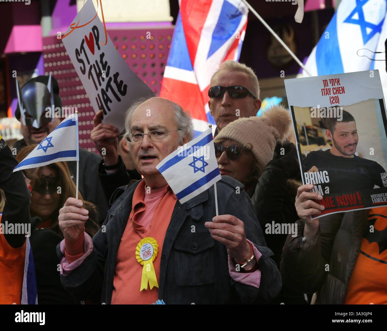 Un manifestant porte une rosette disant "ramène-les à la maison" et agite le drapeau israélien pendant la contre-manifestation. Les manifestants pro-israéliens se rassemblent dans Coventry Street à Londres comme contre-manifestation à un rassemblement pro-palestinien. Les manifestants exigent le retour immédiat de tous les otages détenus par le Hamas. Ils portent des masques Batman et tiennent des pancartes et des ballons orange en hommage à Ariel Bibas, un amoureux de 4 ans du personnage de dessin animé qui a été tué avec d'autres membres de sa famille après une attaque aérienne israélienne alors qu'ils étaient retenus en otage à Gaza. (Photo Martin Pope/SOPA images/SIPA USA) Banque D'Images