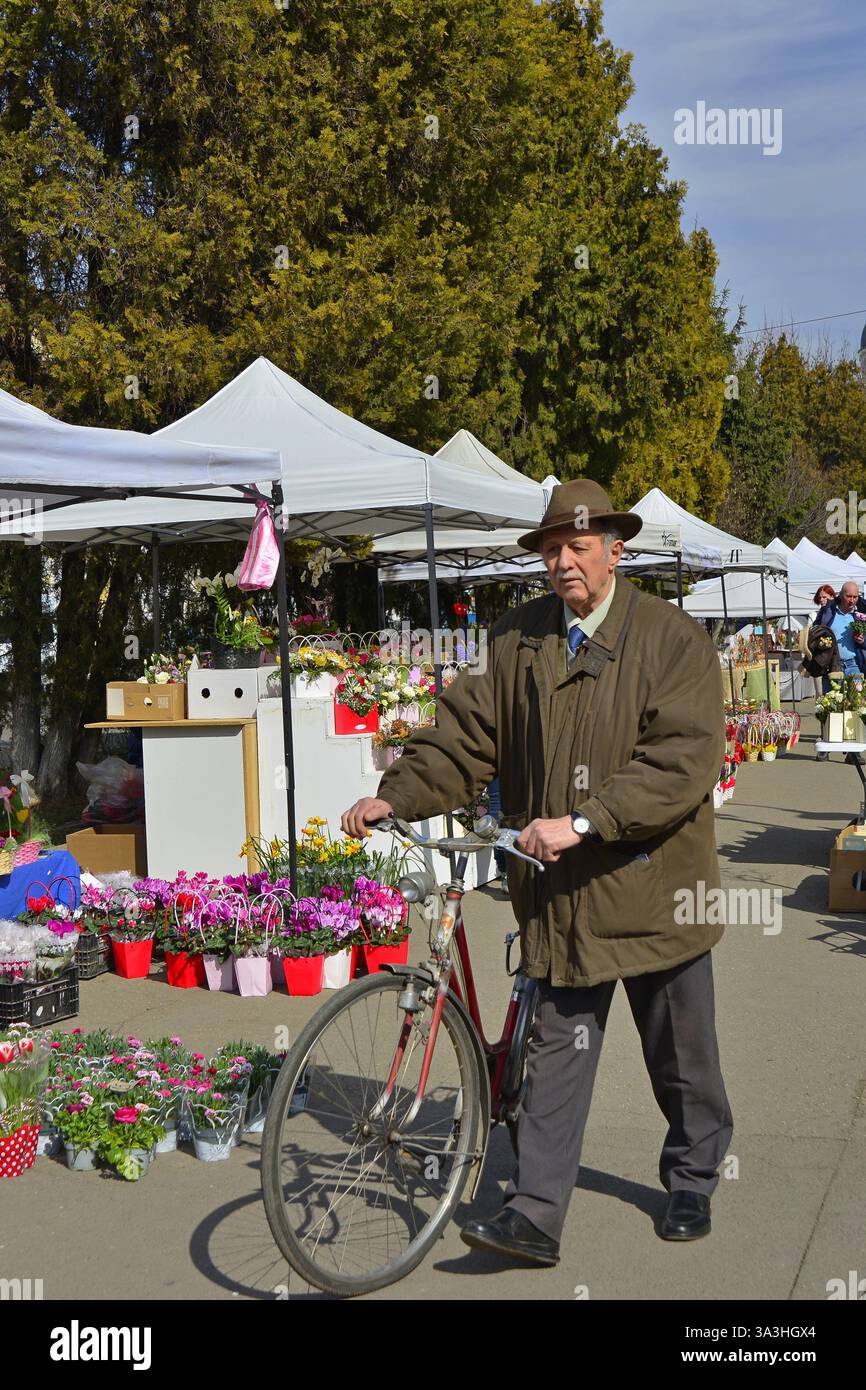Gentleman plus âgé avec une très bonne apparence avec son vélo au marché aux fleurs de Targu Mures Banque D'Images