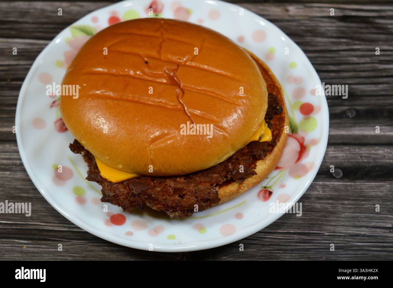 cheeseburger, un hamburger avec une tranche de fromage fondu sur la galette de viande, ajouté vers la fin du temps de cuisson, avec des garnitures de mayonnaise, Banque D'Images