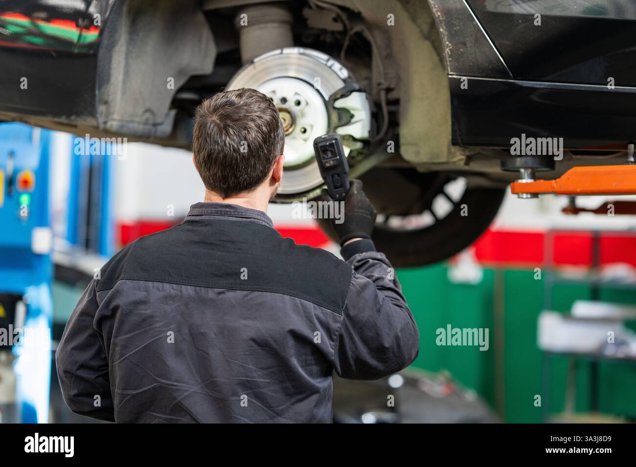 Un technicien vérifie les disques de frein d'une voiture. Banque D'Images Un technicien vérifie les disques de frein d'une voiture. Banque D'Images