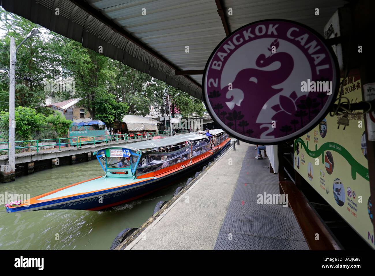 Bangkok, Thaïlande - 7 janvier 2023 : le bateau traditionnel Khlong, un type de ligne de bus nautique, arrive sur une plate-forme pour prendre des passagers dans le canal Saen Saep. Banque D'Images
