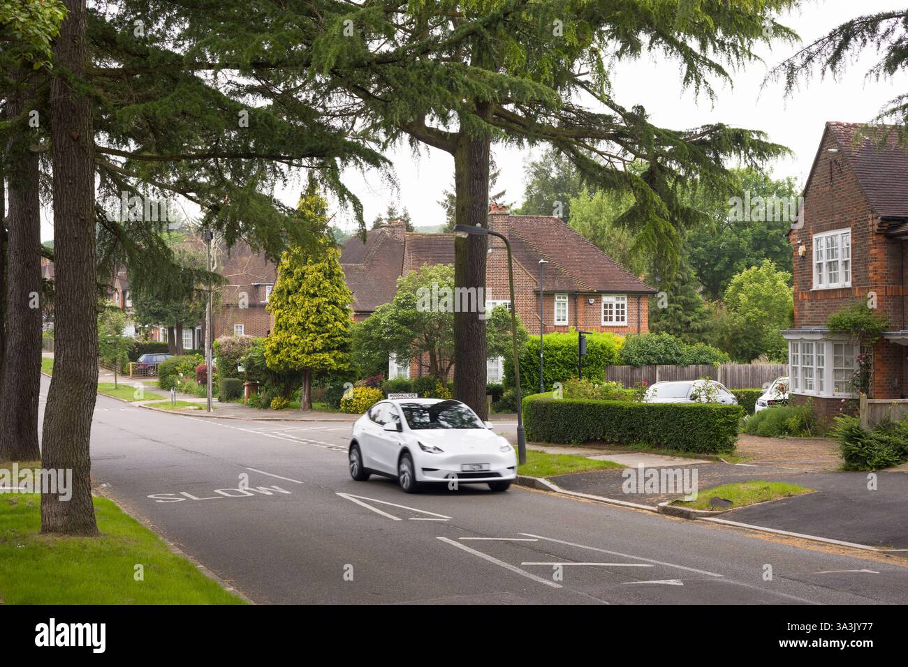 Londres, Royaume-Uni - 18 mai 2024. Tesla EV voiture conduisant dans une banlieue verdoyante de Londres. Pinner, Londres, Royaume-Uni Banque D'Images