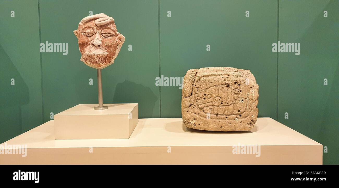 Masque polychrome en stuc d'un captif aux lèvres cousues, site maya Dzibanche et tablette avec glyphe Ajaw d'El Resbalon au Museo de Maya, Cancun, Mexique Banque D'Images