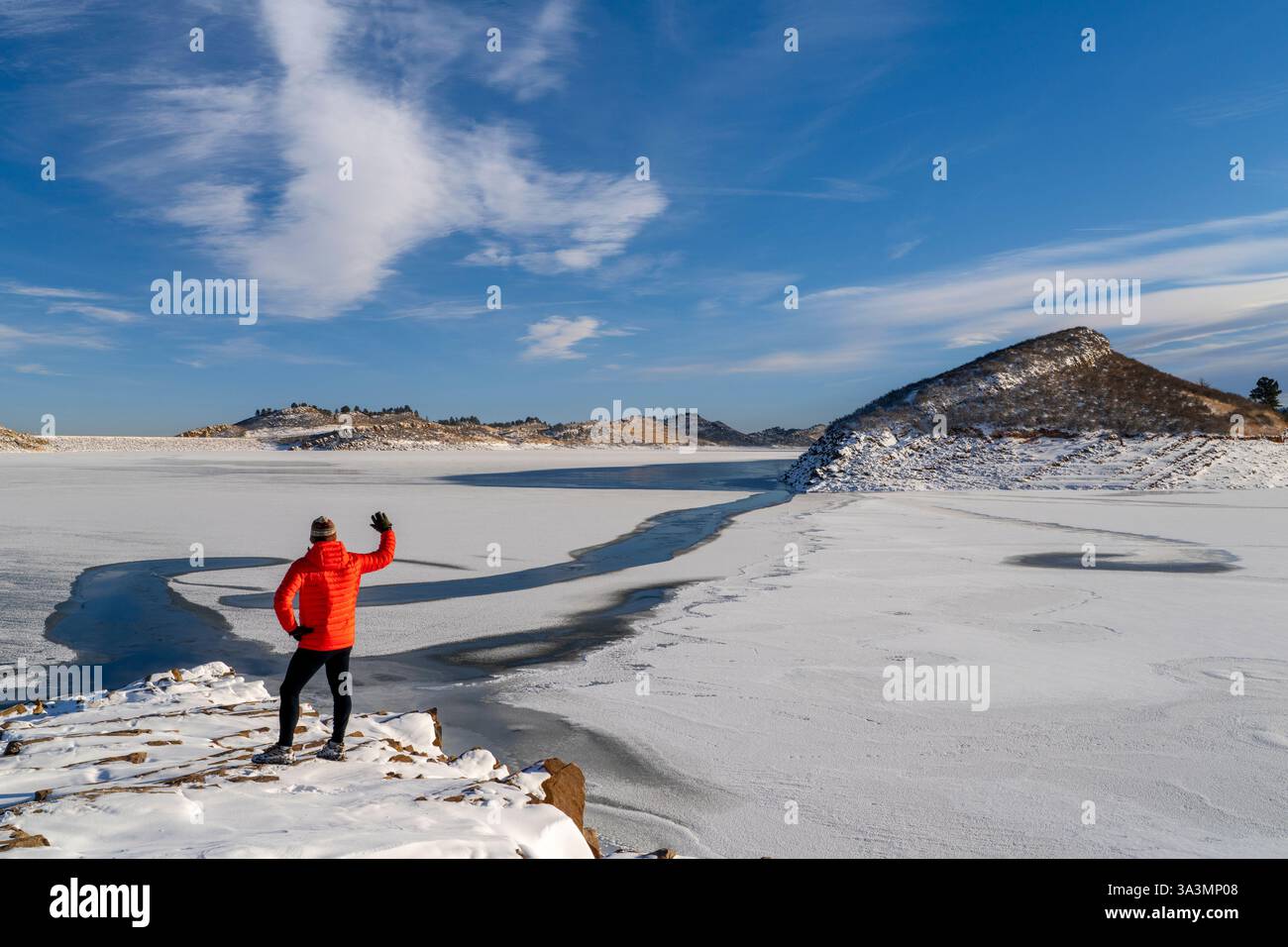 Randonneur masculin en duvet sur un rivage rocheux du réservoir Frozen Horsetooth dans le nord du Colorado Banque D'Images