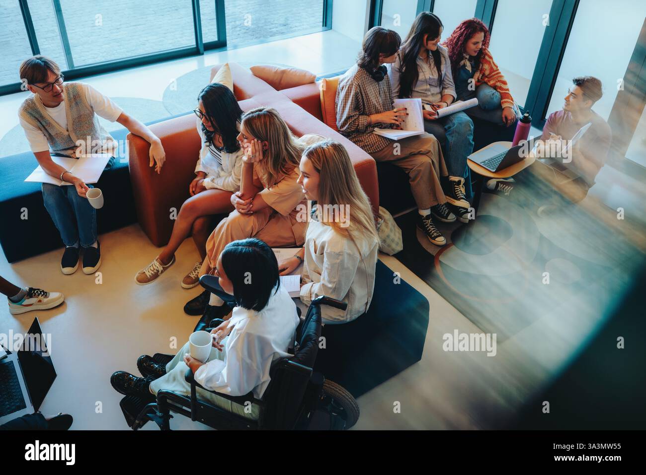 Un groupe diversifié d'étudiants engagés dans des études et des discussions sur le campus, favorisant la collaboration, l'inclusion et le travail d'équipe créatif. Banque D'Images