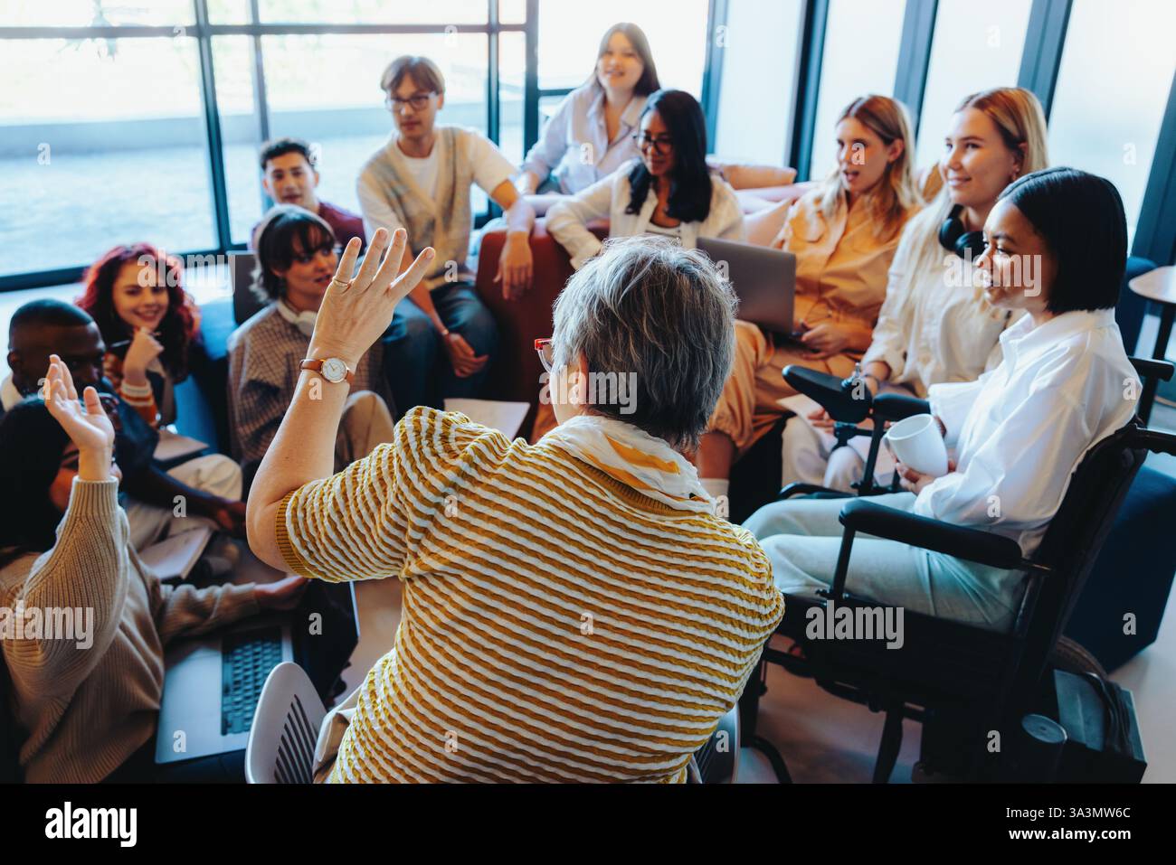 Un groupe diversifié de diplômés universitaires s'engagent dans une discussion animée avec des amis, mettant en évidence la collaboration et le travail d'équipe dans un enseignement moderne en Banque D'Images