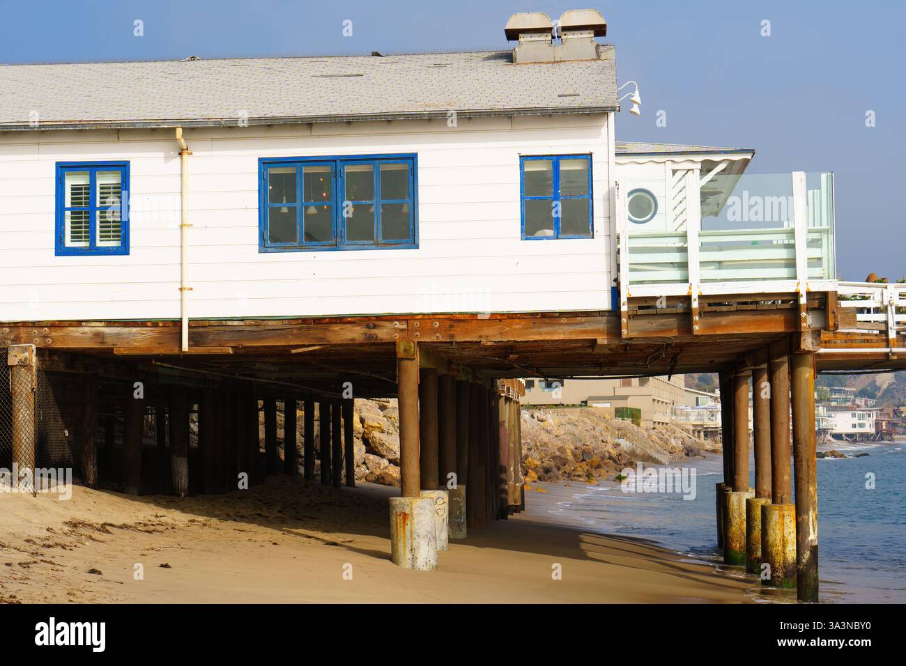 Malibu, Californie - 21 décembre 2024 : Malibu Farm Restaurant perché sur pilotis au-dessus de la plage de sable, avec des fenêtres bleues et une vue dégagée sur l'océan wa Banque D'Images