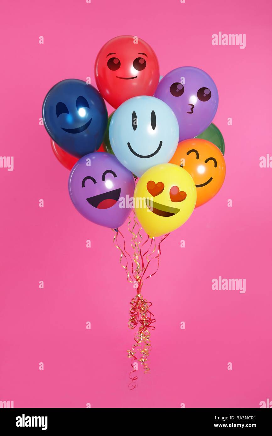 Visages avec des émotions différentes sur des ballons lumineux sur fond rose Banque D'Images