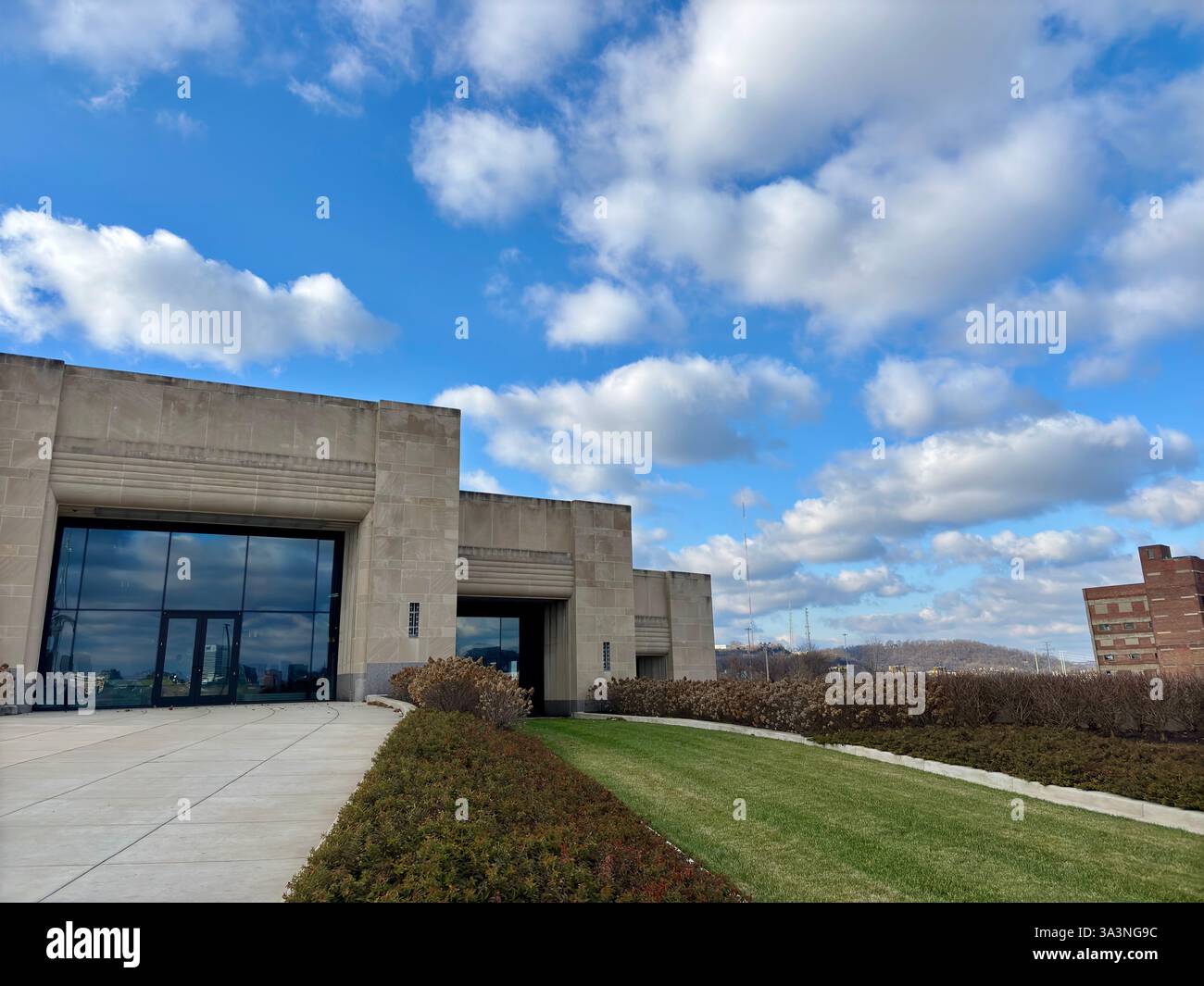 Extérieur du bâtiment moderne avec ciel dégagé et pelouse verte luxuriante Banque D'Images