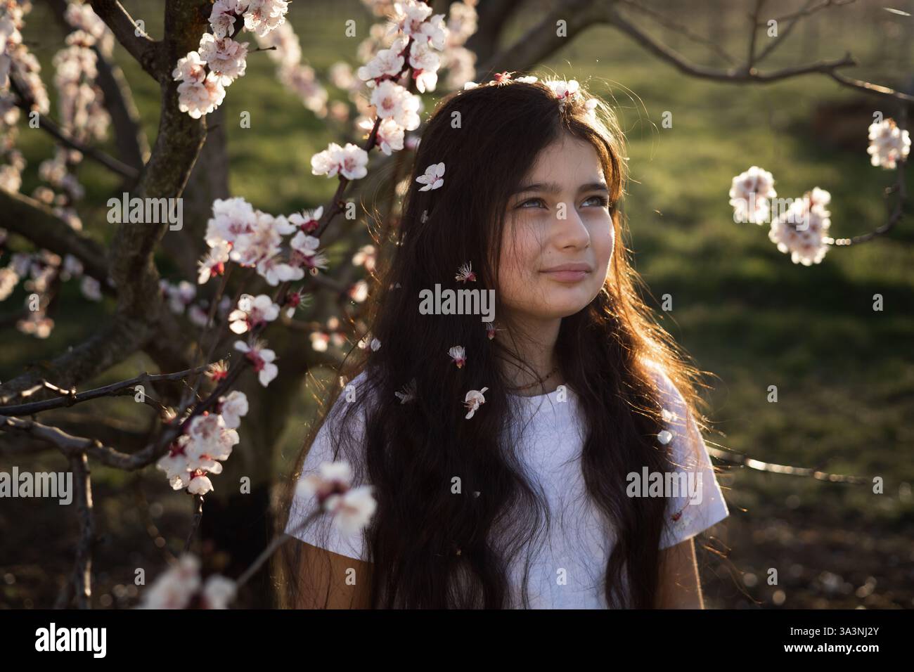 portraits d'adolescentes aux cheveux longs dans un jardin de cerisiers en fleurs Banque D'Images