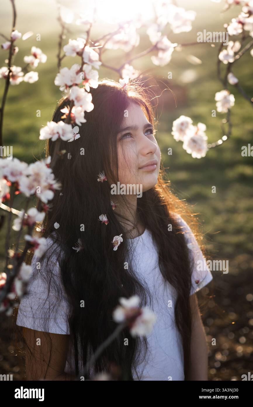 portraits d'adolescentes aux cheveux longs dans un jardin de cerisiers en fleurs Banque D'Images