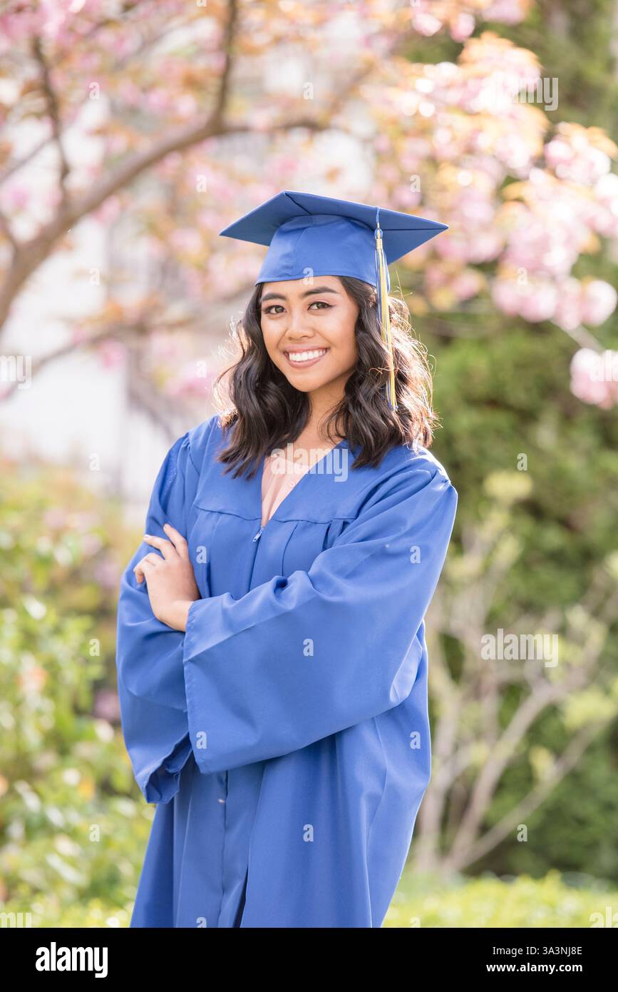 Diplômée confiante célèbre sa réussite sous les fleurs de cerisier Banque D'Images