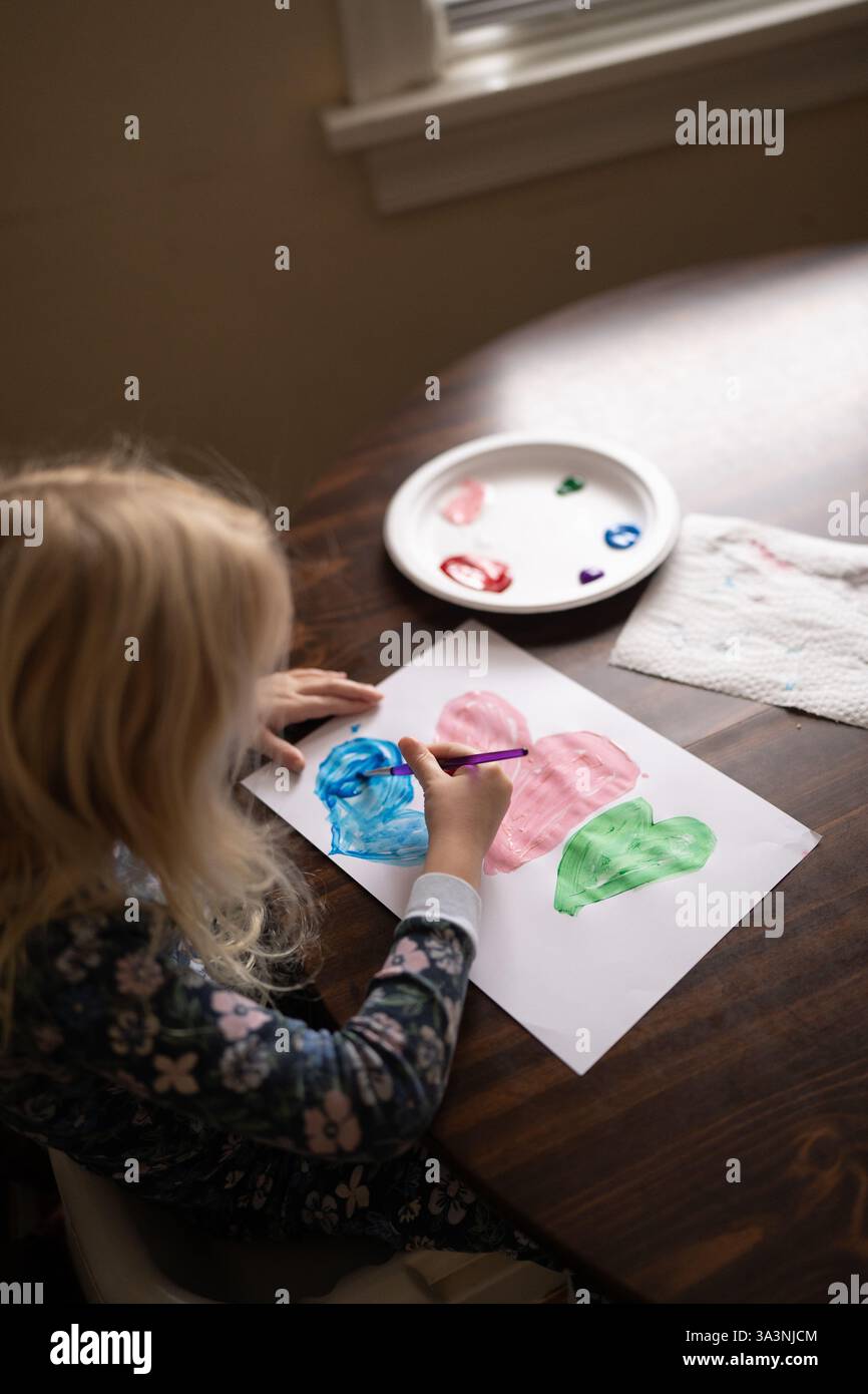 Fille peint des coeurs colorés pour la Saint-Valentin Banque D'Images