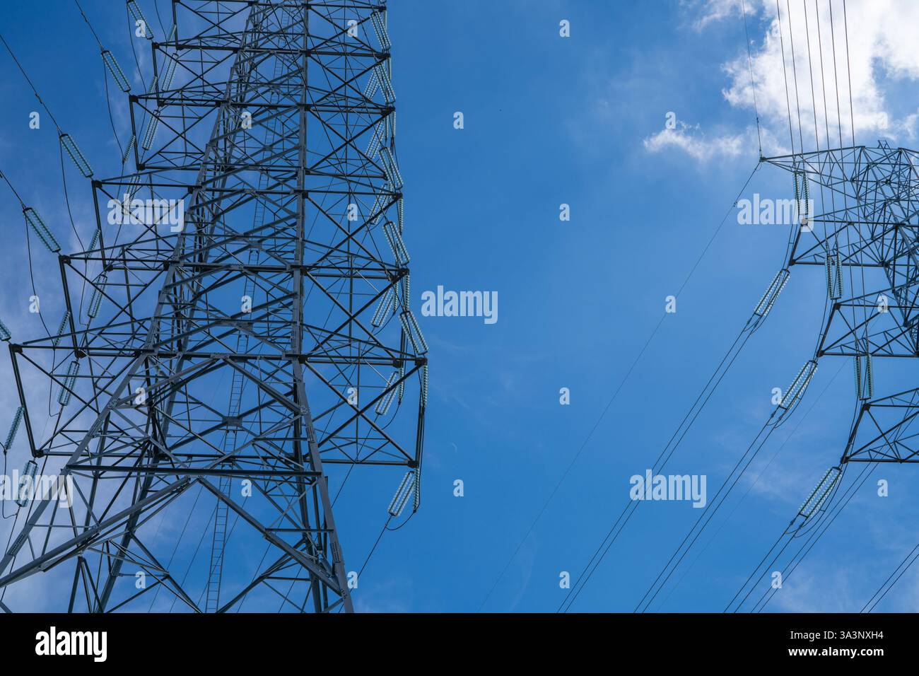 Pylône électrique et lignes de transport d'énergie contre ciel bleu. Approvisionnement en énergie, ingénierie technologique et efficacité des réseaux modernes. Banque D'Images