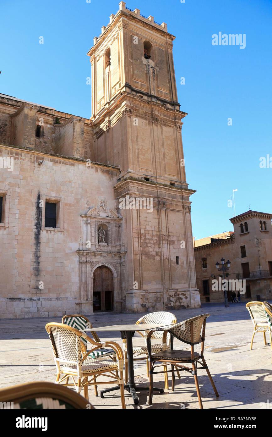 Elche, Alicante, Espagne- 15 mars 2025 : la place du couvent eucharistique avec des terrasses de bar et le chuch Santa Maria en arrière-plan Banque D'Images
