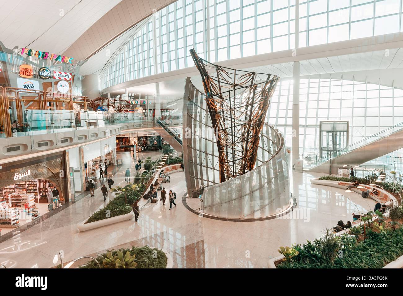 23 janvier 2025, Abu Dhabi, Émirats arabes Unis : vue en angle élevé d'un terminal d'aéroport moderne avec des passagers marchant, faisant du shopping et se relaxant Banque D'Images